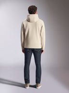 Alpinestars Pulse Kapuzenpullover, lässige Streetwear, Off White, Rückansicht an einem Model in dunklen Denim-Jeans und Sneakern, Fleece-Kapuzenpullover mit Rippbündchen und Saum