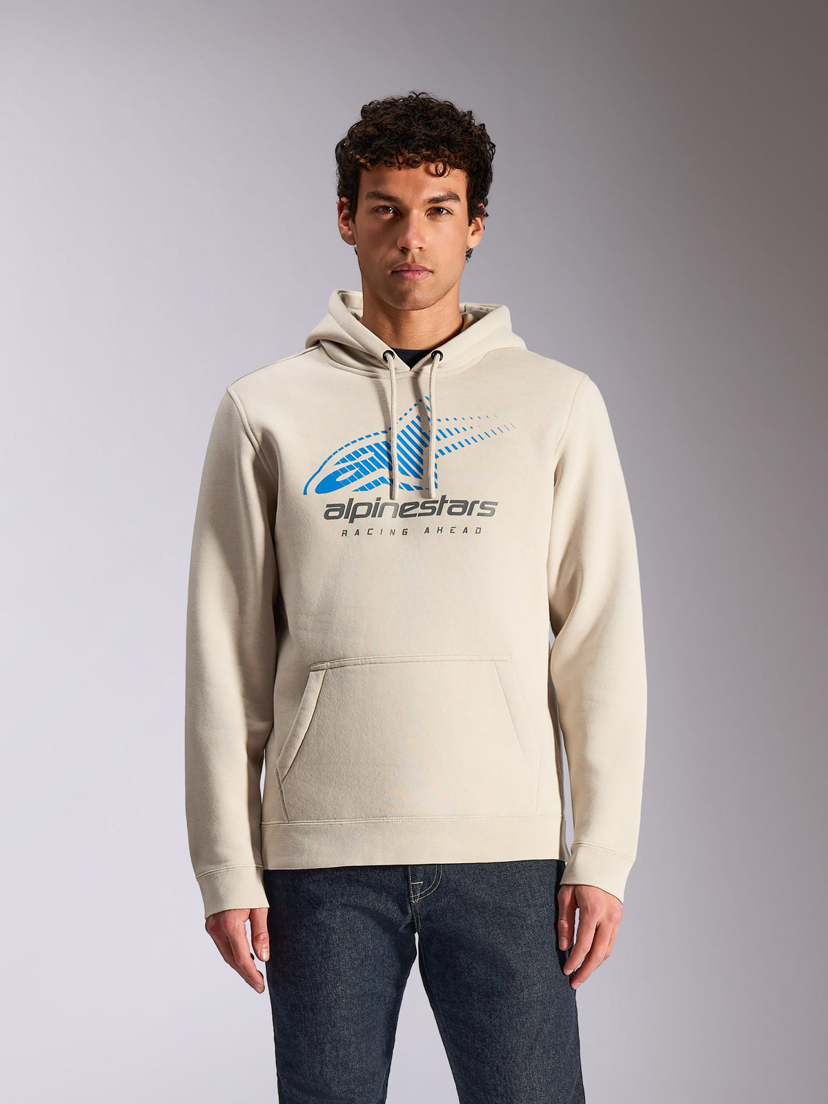 Alpinestars Pulse Hoodie, Off White casual pullover hoodie, front blue and grey Astars Combo Logo with speed line fade graphic, front pouch pocket, worn by model with dark jeans, motorsport-inspired streetwear
