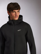 Alpinestars Cypher Hoodie, lässige Sportbekleidung, schwarzer Hoodie mit Frontreißverschluss, weißes Astars-Logo auf der Brust, Kapuzendesign mit hohem Kragen, getragen von einem männlichen Model