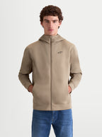 Alpinestars Cypher Hoodie, Men's Full-Zip Sportswear Hoodie, Putty Beige, featuring a high-neck hood, tri-blend double-face fleece fabric, and a black Alpinestars chest logo, on-model front view with hands in pockets.