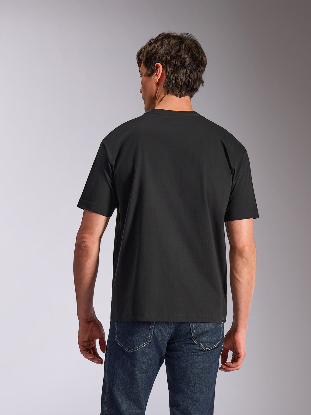 Alpinestars Aplomb Oversized CSF Tee, Short Sleeve T-Shirt, Black, back view, worn by model with blue jeans, relaxed fit casual sportswear