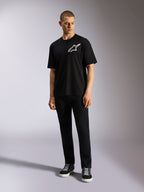 Alpinestars One Oversized CSF Tee, Kurzarm-T-Shirt, Schwarz, weißes Astars-Logo auf der Brust, Oversized-Passform, getragen von Model mit schwarzer Hose und Sneakern, lässige Lifestyle-Streetwear