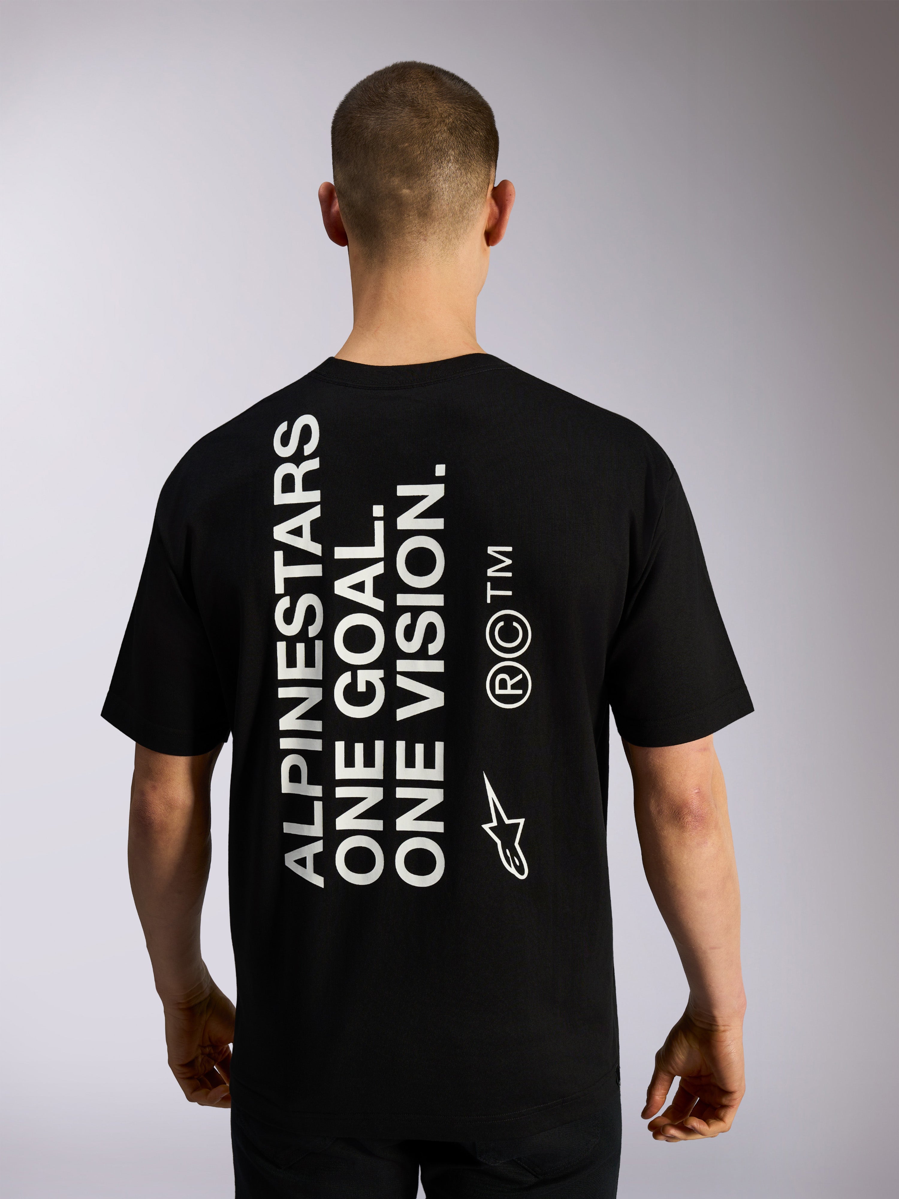 Alpinestars One Oversized CSF Tee, Kurzarm-T-Shirt, Schwarz, Rückansicht mit großem vertikalem weißem „ALPINESTARS ONE GOAL. ONE VISION.“ Schriftzug und Markenlogos, lässige Motorsport-Streetwear
