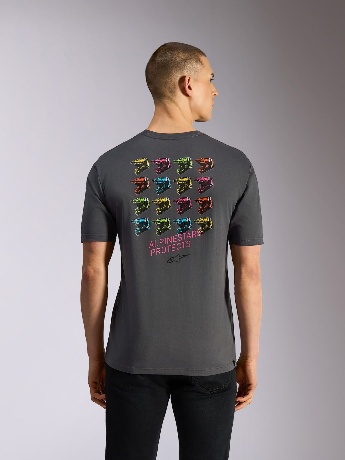 Alpinestars Pop Helmet CSF Tee, kurzärmeliges T-Shirt, Grau, Rückansicht mit einem lebhaften Raster aus 16 farbenfrohen M10-Helmen und pinkem „ALPINESTARS PROTECTS“-Schriftzug auf dem Rücken, lässige, vom Motorsport inspirierte Streetwear