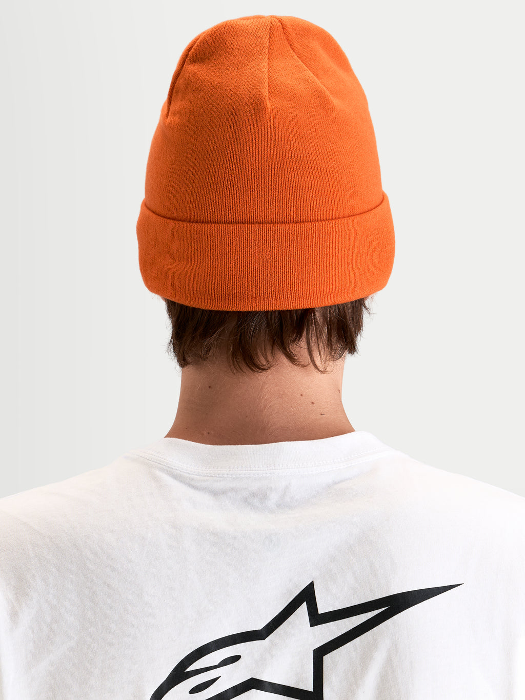 Alpinestars Augment Cuff Mütze, orange Strickmütze mit tiefer Passform und Umschlagdesign, Rückansicht an einem Model im weißen T-Shirt mit schwarzem Astar-Logo
