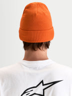 Alpinestars Augment Cuff Mütze, orange Strickmütze mit tiefer Passform und Umschlagdesign, Rückansicht an einem Model im weißen T-Shirt mit schwarzem Astar-Logo