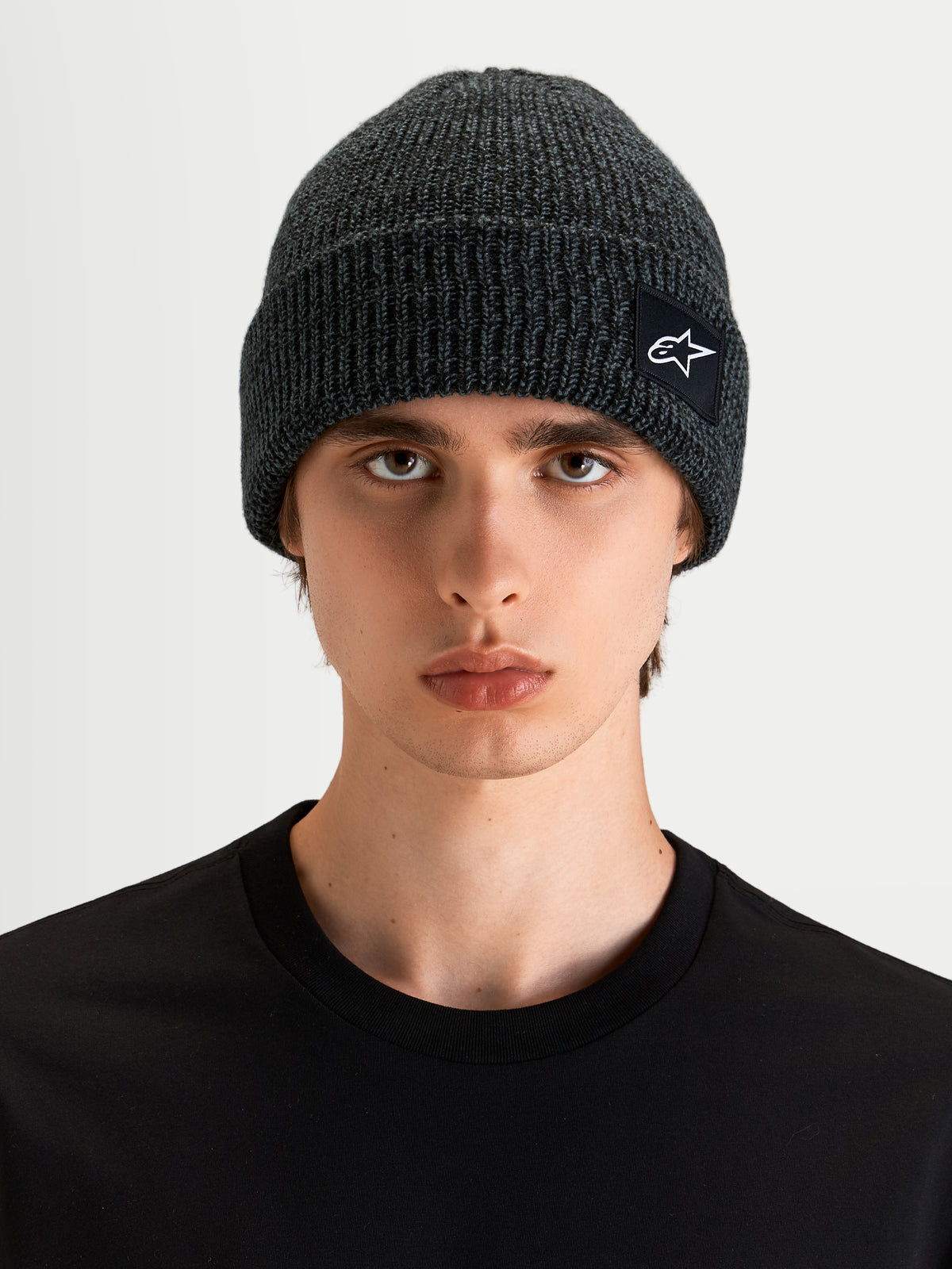 Alpinestars Unload Rib Cuff Mütze, dunkelgraue Sportswear-Strickmütze an einem Model, mit Rippstrick-Design und SAstars-Webaufnäher