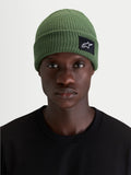 Alpinestars Unload Rib Cuff Mütze, grüne Sportswear-Mütze im Strickdesign mit flacher Passform und gewebtem SAstars-Aufnäher, getragen von einem Model