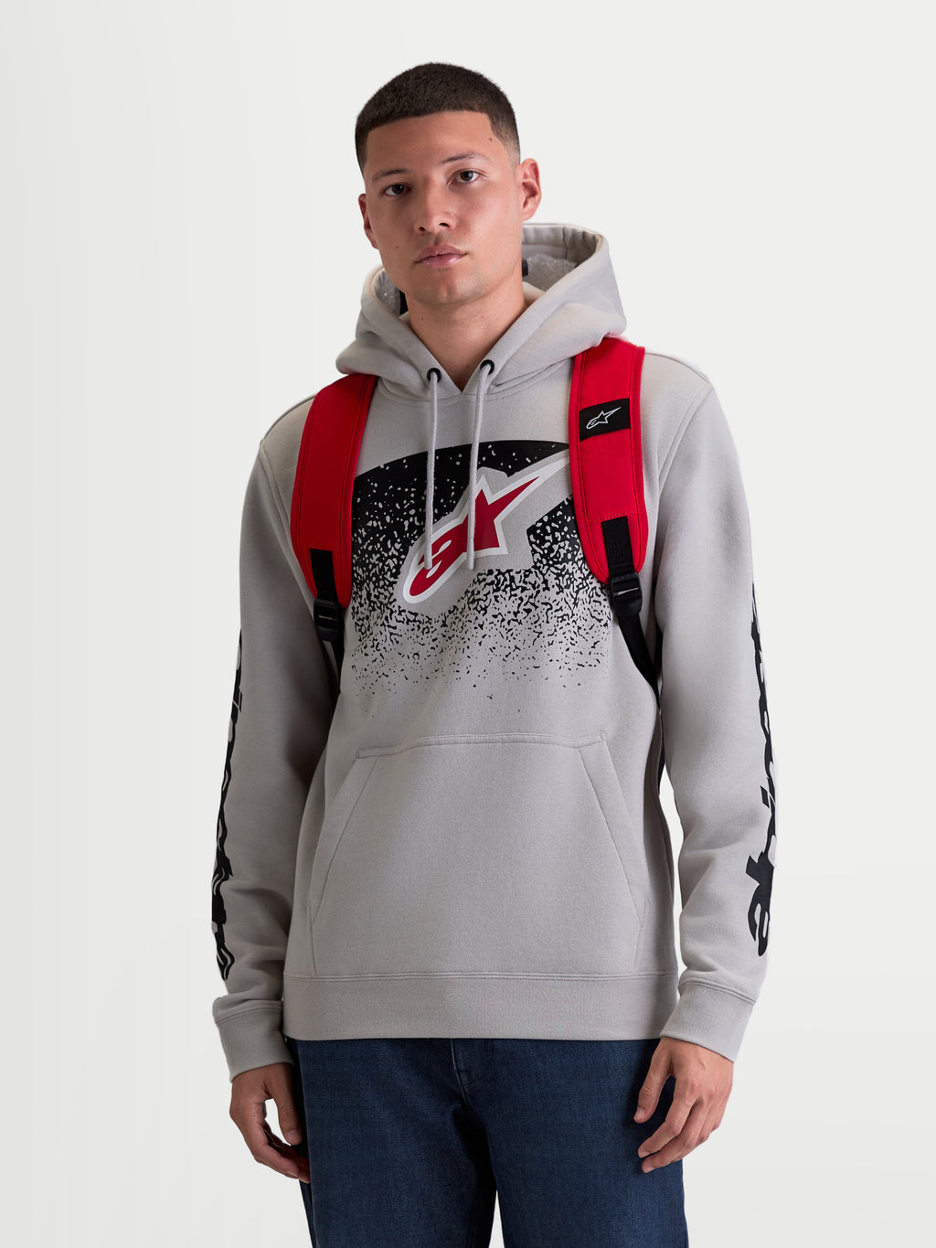 Alpinestars GFX Boss Rucksack, urbaner Sport-Tagesrucksack für Herren und Damen, Rot und Schwarz, strapazierfähiges 600D Polyester, Vorderansicht am Modell mit verstellbaren Air-Mesh-Schultergurten und erhabenem Silikon-Branding, 20L Kapazität.