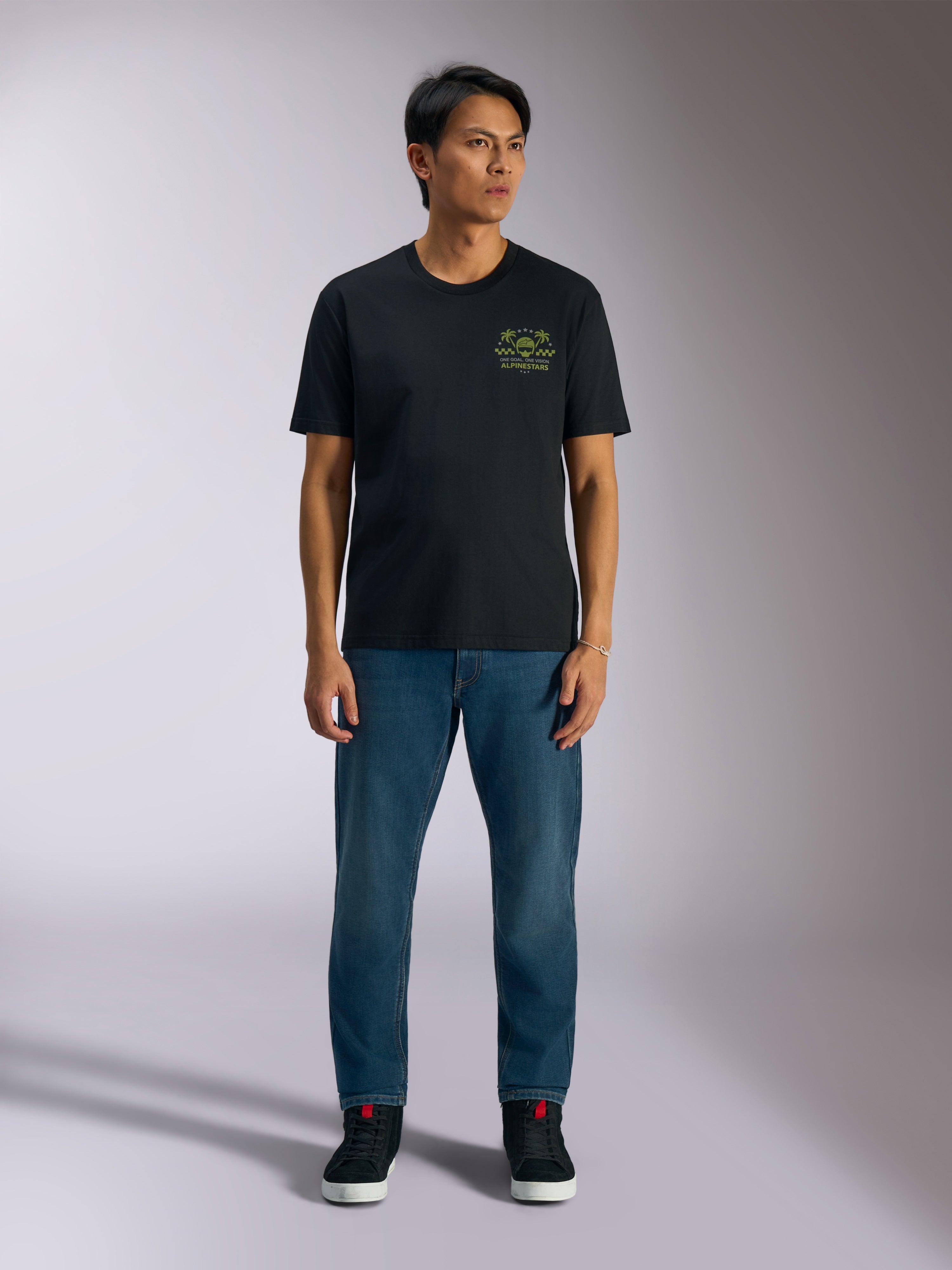 Alpinestars Order CSF Tee, Short Sleeve T-Shirt, Black, Lime Green Graphic with Helmet and Palm Trees on chest, worn with blue jeans and black sneakers, Casual Motorsport Streetwear