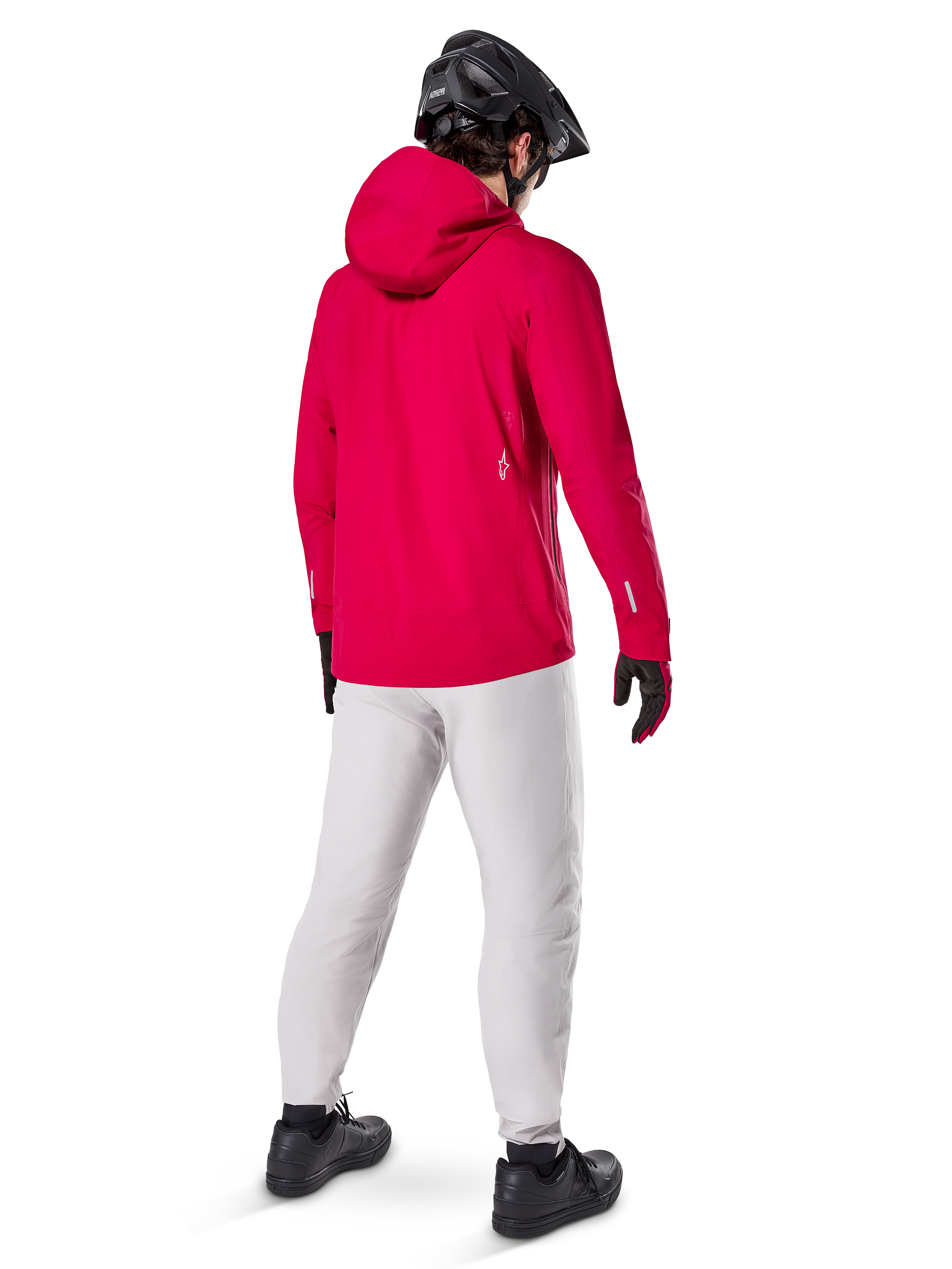 Alpinestars A-Dura Elite Waterproof Jacket, Red Fluo, three-quarter back view, worn with light gray pants and black MTB helmet, features a hood and reflective accents, high-performance cycling rain jacket for trail riding