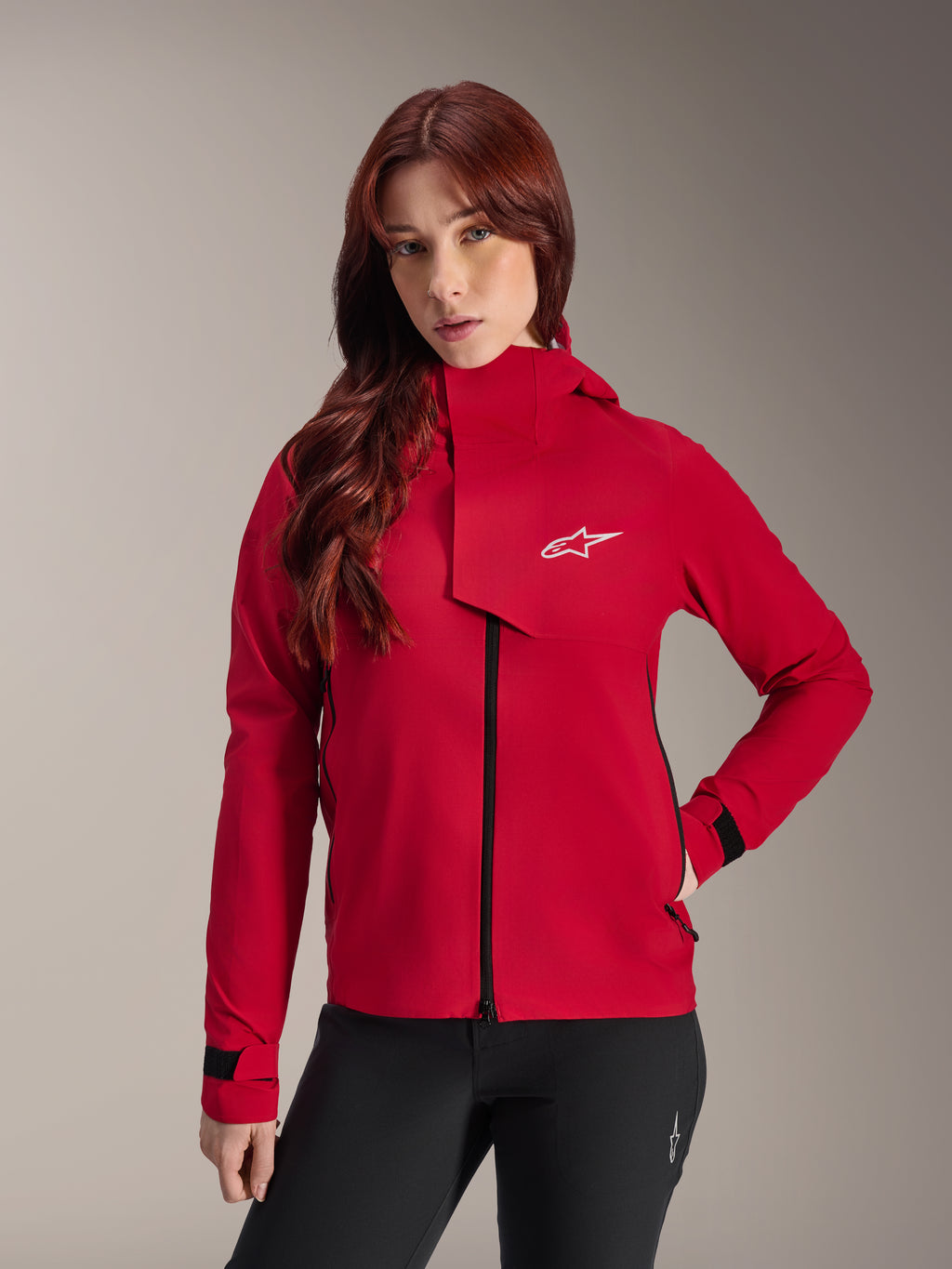 Alpinestars Stella A-Dura Elite Wasserdichte Jacke, Damen-Mountainbike-Jacke, Red Fluo, mit einer vorderen Frontklappe mit weißem Alpinestars-Logo, hohem Kragen und verstellbaren Ärmelbündchen, getragen mit einer schwarzen Hose für einen technischen Riding-Look