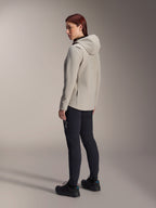 Alpinestars Stella A-Dura Thermal Jacke in Titanium Grau, Dreiviertel-Rückansicht einer Frau, die die isolierte Fahrradjacke mit Kapuze und eine schwarze MTB-Hose trägt, Studioaufnahme zeigt die reguläre Passform und Taschendetails.