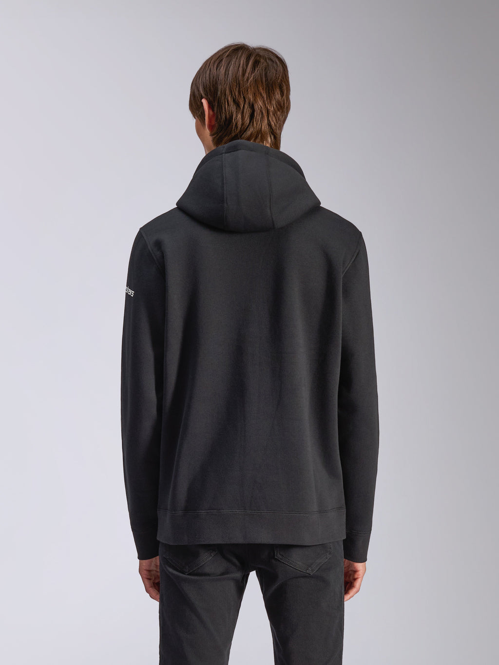 Alpinestars Frontal Hoodie, Schwarz, Rückansicht eines lässigen Kapuzenpullovers mit selbstgefütterter Kapuze, geripptem Saum und weißem Wortmarken-Logo am Ärmel, Motorsport-inspirierte Streetwear.
