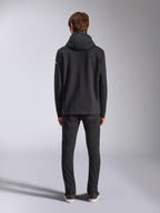 Alpinestars Frontal Hoodie, lässige Streetwear, Schwarz, Rückansicht eines Models im Fleece-Kapuzenpullover, mit Rippbündchen an Saum und Ärmeln, kleines weißes Wortmarken-Logo am Ärmel, kombiniert mit schwarzer Hose