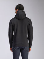 Alpinestars Blaze V3 Kapuzenpullover, Rückansicht eines schwarzen Fleece-Kapuzenpullovers, lässige Streetwear, mit Rippbündchen an Ärmeln und Saum, Kapuze mit Jersey-Futter, getragen mit dunkelblauen Jeans
