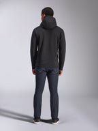 Alpinestars Blaze V3 Hoodie, lässige Streetwear, Schwarz, Rückansicht eines Fleece-Kapuzenpullovers, kombiniert mit dunkelblauer Denim-Jeans und schwarzen Schuhen, cleanes, vom Motorsport inspiriertes Design