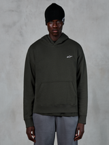 Alpinestars Essentials Ageless Hoodie, lässige Streetwear, Off-Black-Pullover mit einem kleinen weißen Alpinestars-Logo auf der Brust, getragen mit einer schwarzen Beanie, minimalistisches Design mit Kängurutasche vorne und Stone-Wash-Finish