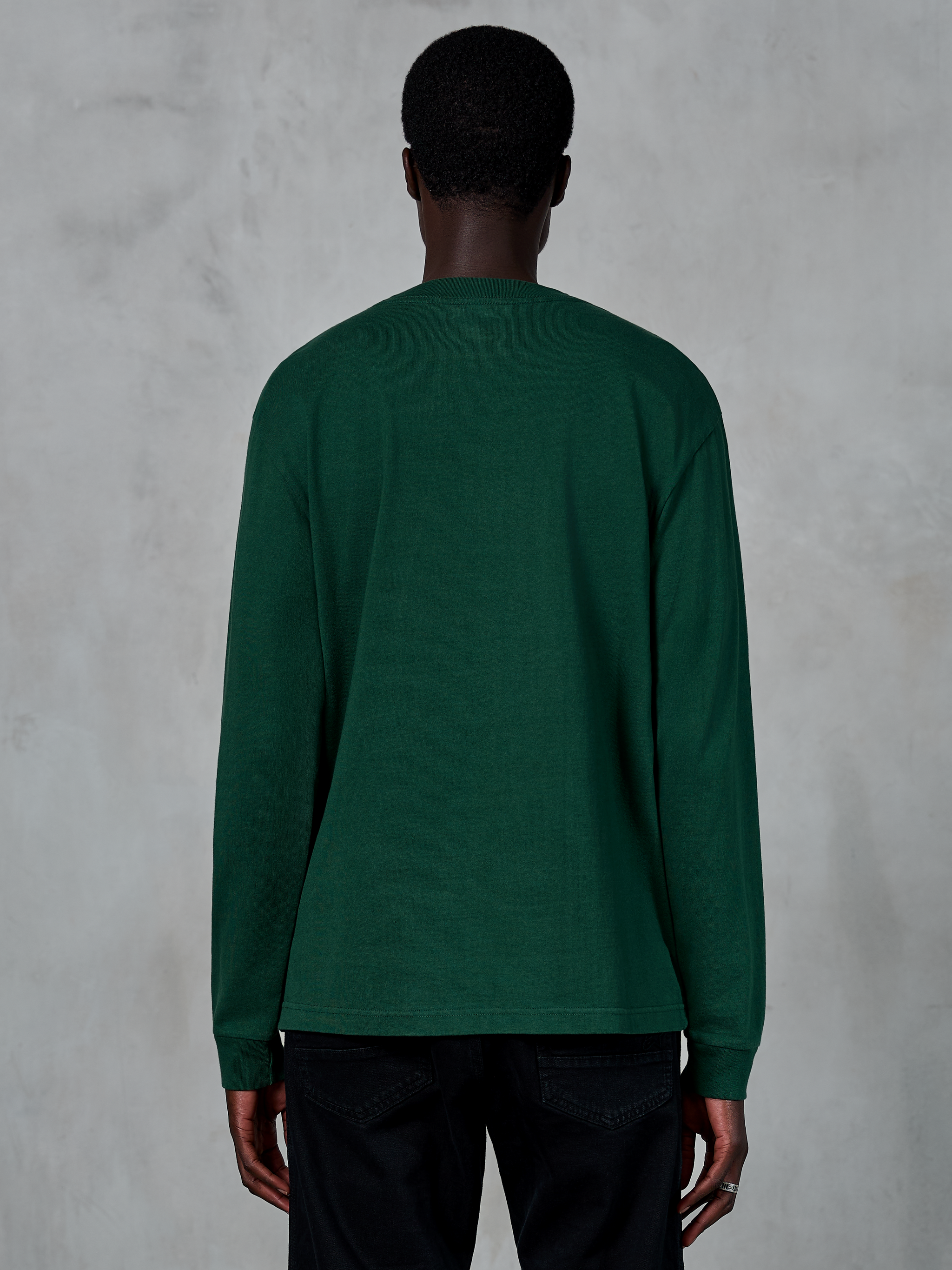 Alpinestars Essentials Ageless LS Tee, Langarmshirt, Pine Green, Rückansicht eines Models in einem locker sitzenden T-Shirt aus Bio-Baumwolljersey, lässige, vom Motorsport inspirierte Streetwear