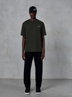 Alpinestars Essentials Ageless SS Tee, Short Sleeve T-Shirt, Off Black, featuring a small white Alpinestars logo on the chest, worn by a model with a black cap and trousers for a clean lifestyle look