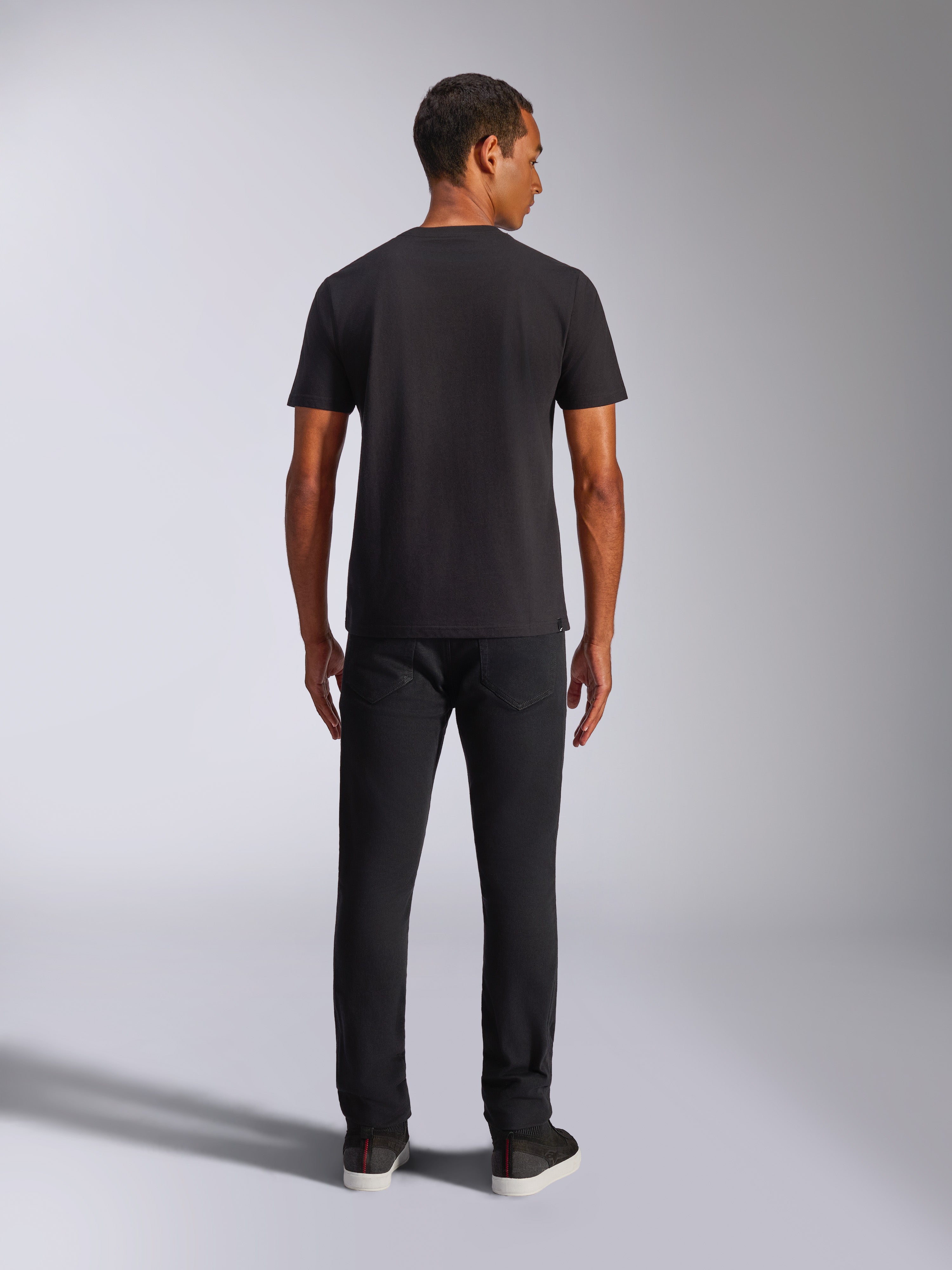 Alpinestars Shaded CSF Tee, Kurzarm-T-Shirt, Schwarz, Rückansicht an einem Model in schwarzer Hose, lässige, vom Motorsport inspirierte Streetwear