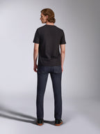 Alpinestars Global CSF T-Shirt, Kurzarm-T-Shirt in Schwarz, Rückansicht eines männlichen Modells, das das Shirt mit dunklen Denim-Jeans trägt, lässige vom Motorsport inspirierte Streetwear