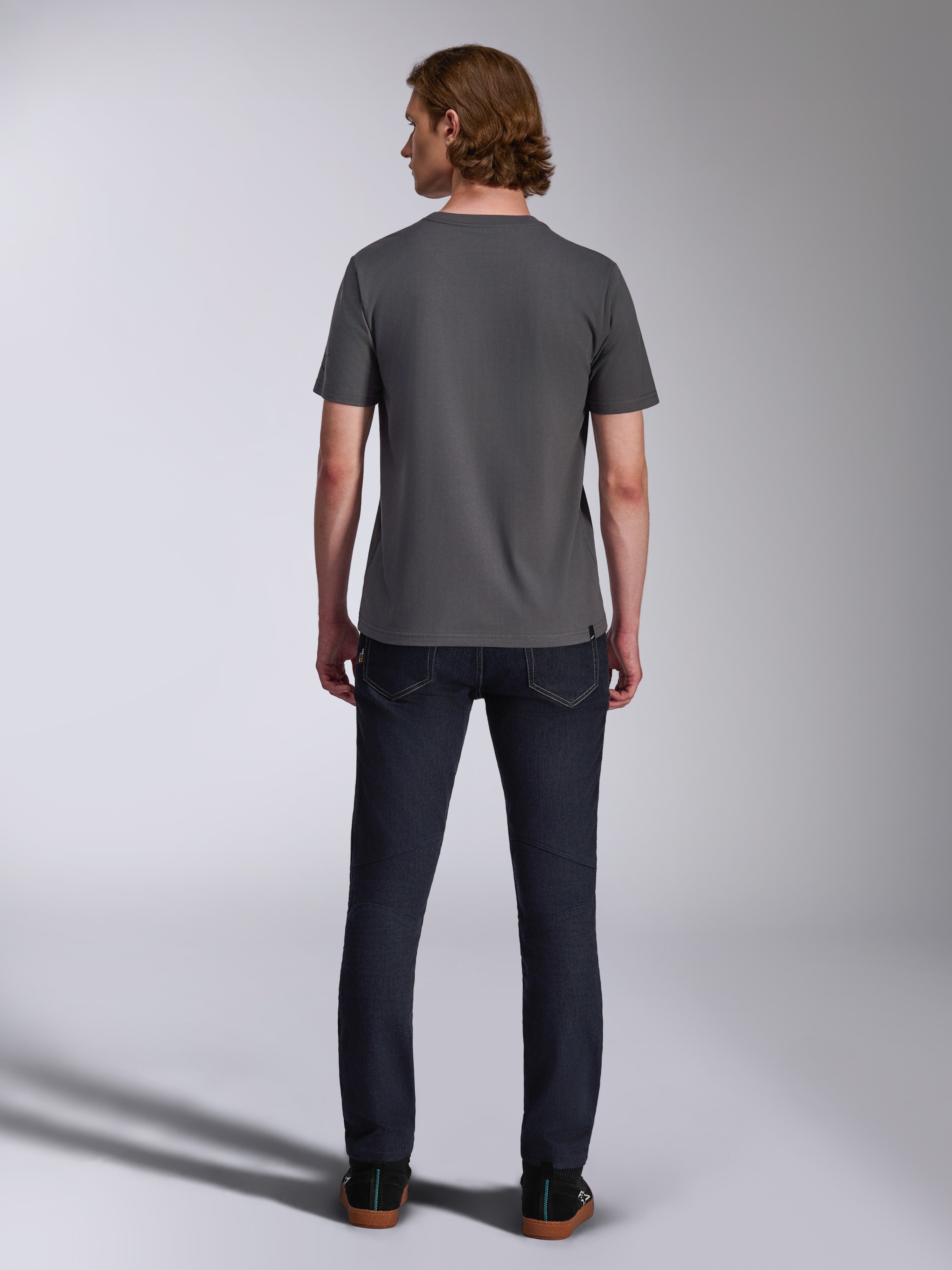 Alpinestars Waving CSF Tee, Kurzarm-T-Shirt, Anthrazit, Rückansicht, getragen mit dunklen Denim-Jeans, lässige, vom Motorsport inspirierte Streetwear