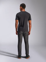 Alpinestars Tech Boot CSF Tee, Kurzarm-T-Shirt, Schwarz, Rückansicht am Modell, kombiniert mit dunkelgrauen Jeans und schwarzen Sneakern, lässige, vom Motorsport inspirierte Streetwear