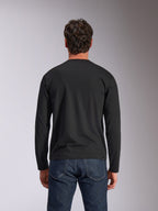 Alpinestars Trackside CSF Tee, Langarmshirt, Schwarz, Rückansicht, getragen mit dunkelblauen Denim-Jeans, lässige Motorsport-inspirierte Streetwear