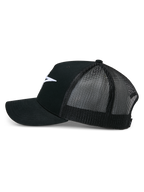 Alpinestars Ageless Trucker-Mütze, Schwarz, Seitenansicht, strukturierte Vorderseite aus Baumwolltwill mit weiß aufgesticktem Astars-Logo, atmungsaktive Rückseite aus schwarzem Mesh, gebogener Schirm, lässige Motorsport-Kopfbedeckung