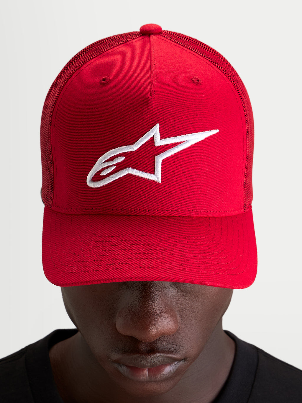 Alpinestars Ageless Snapback Kappe, Sportswear-Cap, rot mit weißem, gesticktem Astars-Logo, strukturierter Krone und gebogenem Schirm, getragen von einem Model