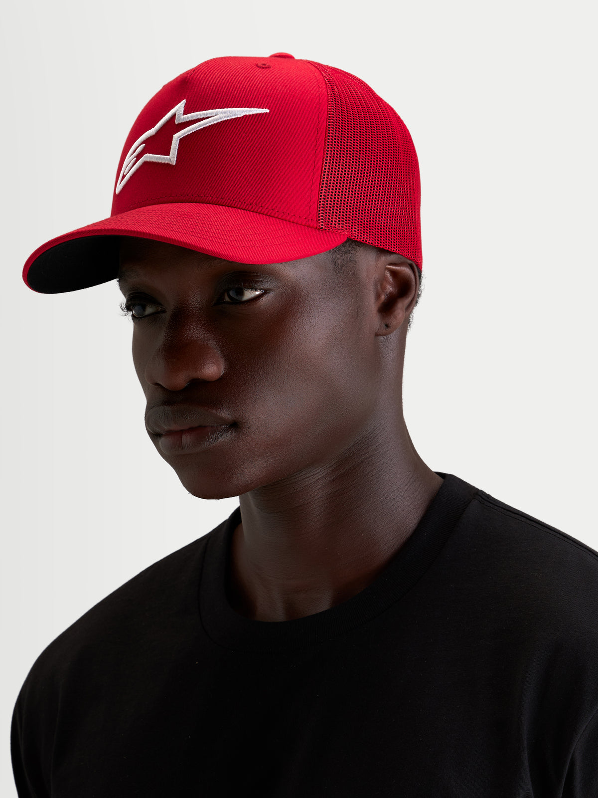 Alpinestars Ageless Snapback Kappe, rote Sportswear-Kappe getragen von einem Model, mit auffälliger 3D-Astars-Logostickerei und gebogenem Schirm, aus Baumwoll-Twill und Mesh-Konstruktion