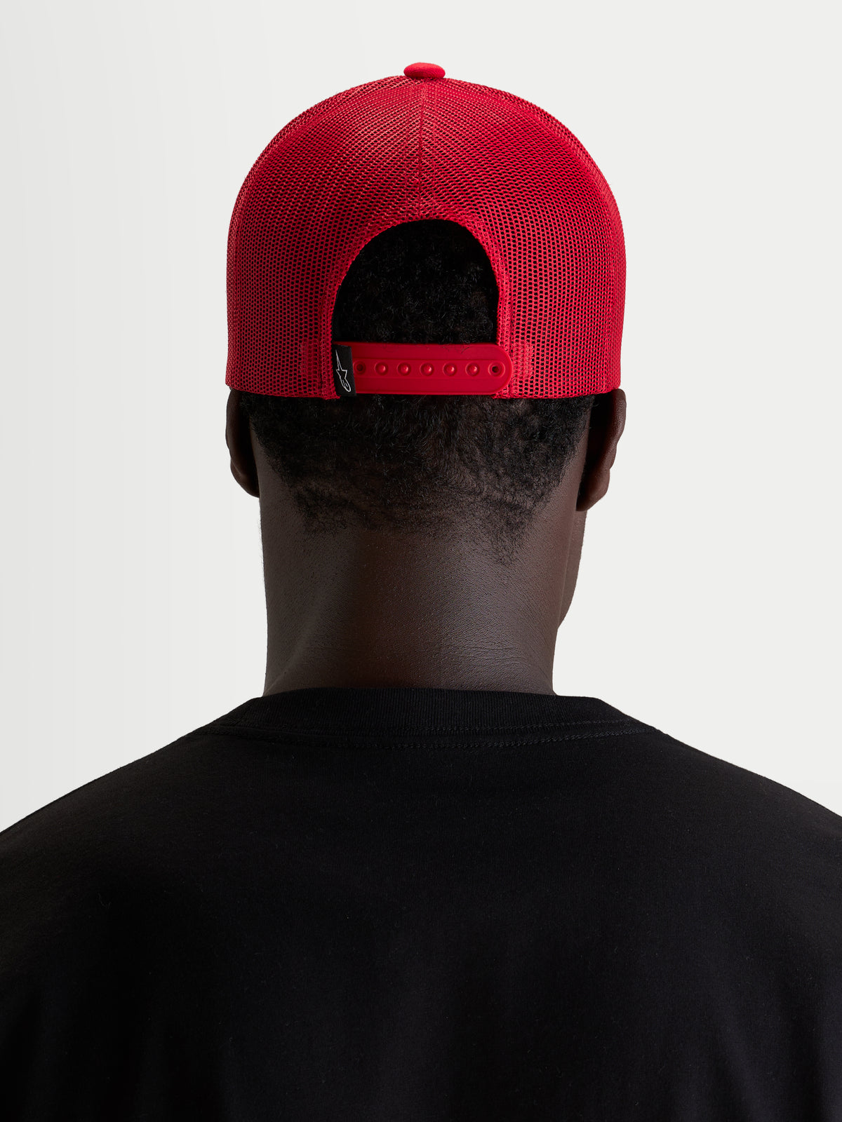Alpinestars Ageless Snapback Kappe, rote Sportswear-Cap, Rückansicht mit verstellbarem Snapback-Verschluss und Mesh-Einsätzen, getragen von einem Model