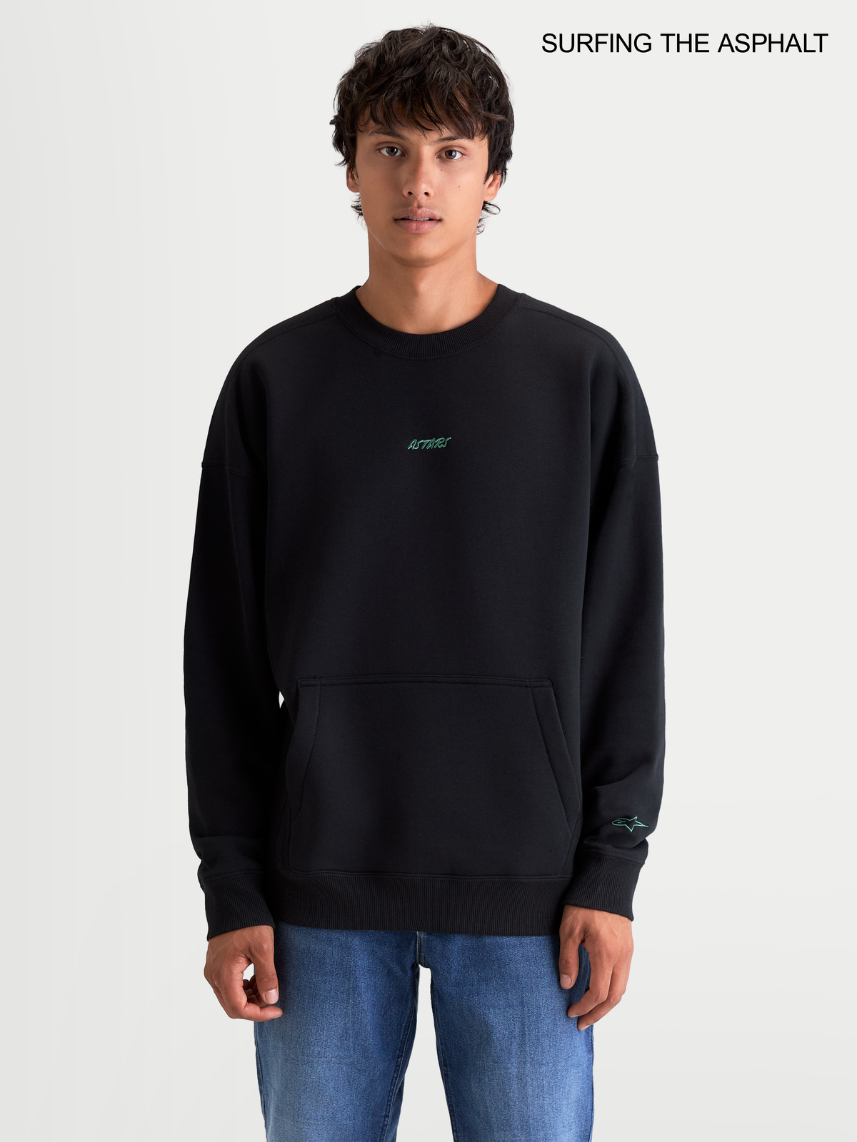 Alpinestars Guise Oversized Crew, schwarzer Fleece-Pullover für Herren in Oversized-Passform, mit Rundhalsausschnitt und Kängurutasche, getragen von einem männlichen Model