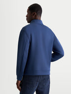 Alpinestars Apera Half-Zip-Sweatshirt, Herren-Sportswear-Pullover, Blau, Tri-Blend-Doppelgewebe-Fleece, Rückansicht auf Model zeigt raffinierte Ärmelnähte und klares motorsport-inspiriertes Design.