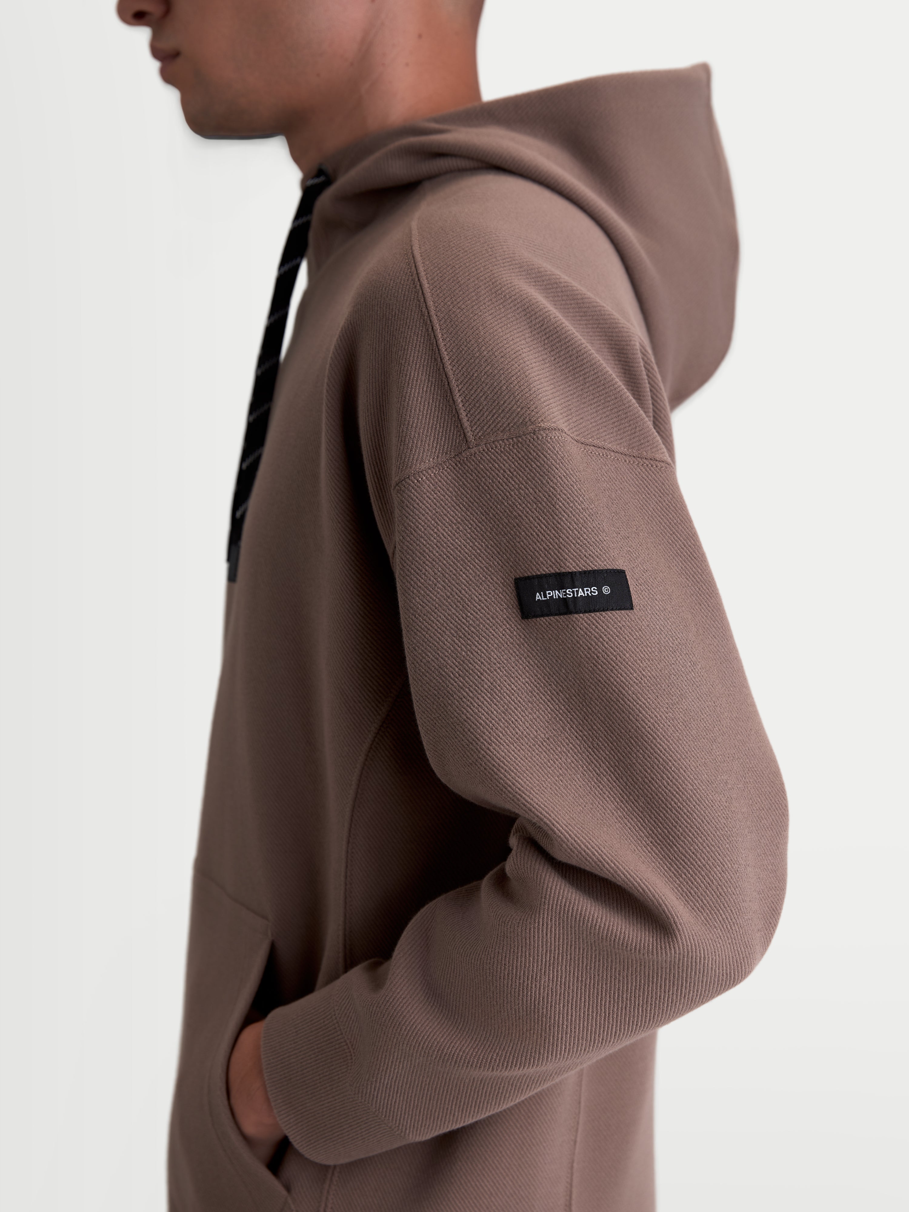 Alpinestars Camino Textured Oversized Hoodie, Casual Sportswear Pullover, Taupe Brown, Textured Knit Twill Fleece, side profile view showing woven sleeve label and high collar.