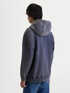 Alpinestars Infinite Washed Oversized Hoodie, Sportswear-Kapuzenpullover in Washed Navy-Blau, Snow-Wash-Finish aus Baumwoll-Fleece, mit Alpinestars-Wortmarke und „One Goal One Vision“-Stickerei auf der Kapuze, Rückansicht am Model, lässige Oversized-Passform.