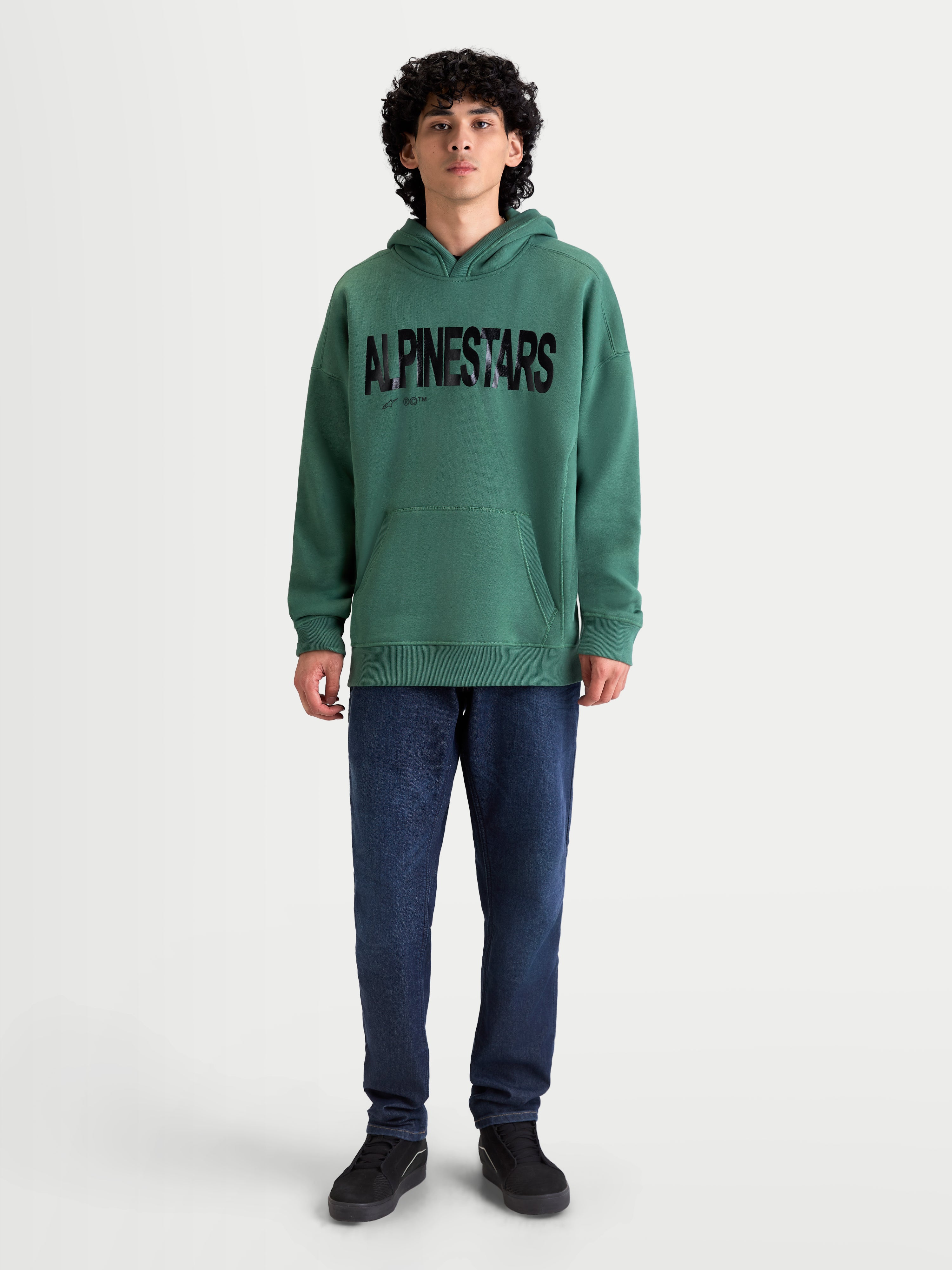 Alpinestars Shaw Oversized Hoodie, Sportswear Pullover Fleece, Green with Black Textured Front Logo, Oversized Fit, Cotton and Recycled Polyester Blend, featuring a kangaroo pocket and self-lined hood, shown on-model.