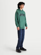 Alpinestars Shaw Oversized Hoodie, Herren-Sportswear-Pullover, Grün, mit strukturiertem Alpinestars-Wortlogo, Kängurutasche und entspannter Oversize-Passform aus weichem Baumwoll- und Recycling-Polyester-Fleece, am Modell getragen.
