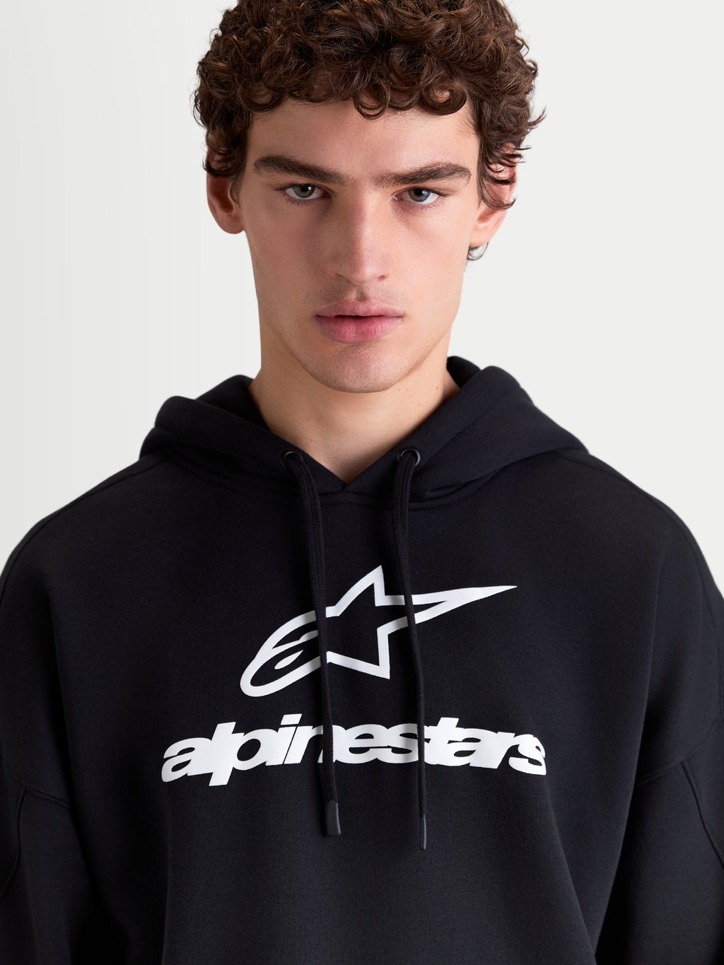 Alpinestars Prelude Oversized Hoodie, Sportswear Fleece Pullover, Black and White, featuring a bold puff-print chest logo, self-lined hood with flat drawcords, and a relaxed oversized fit for casual everyday comfort.