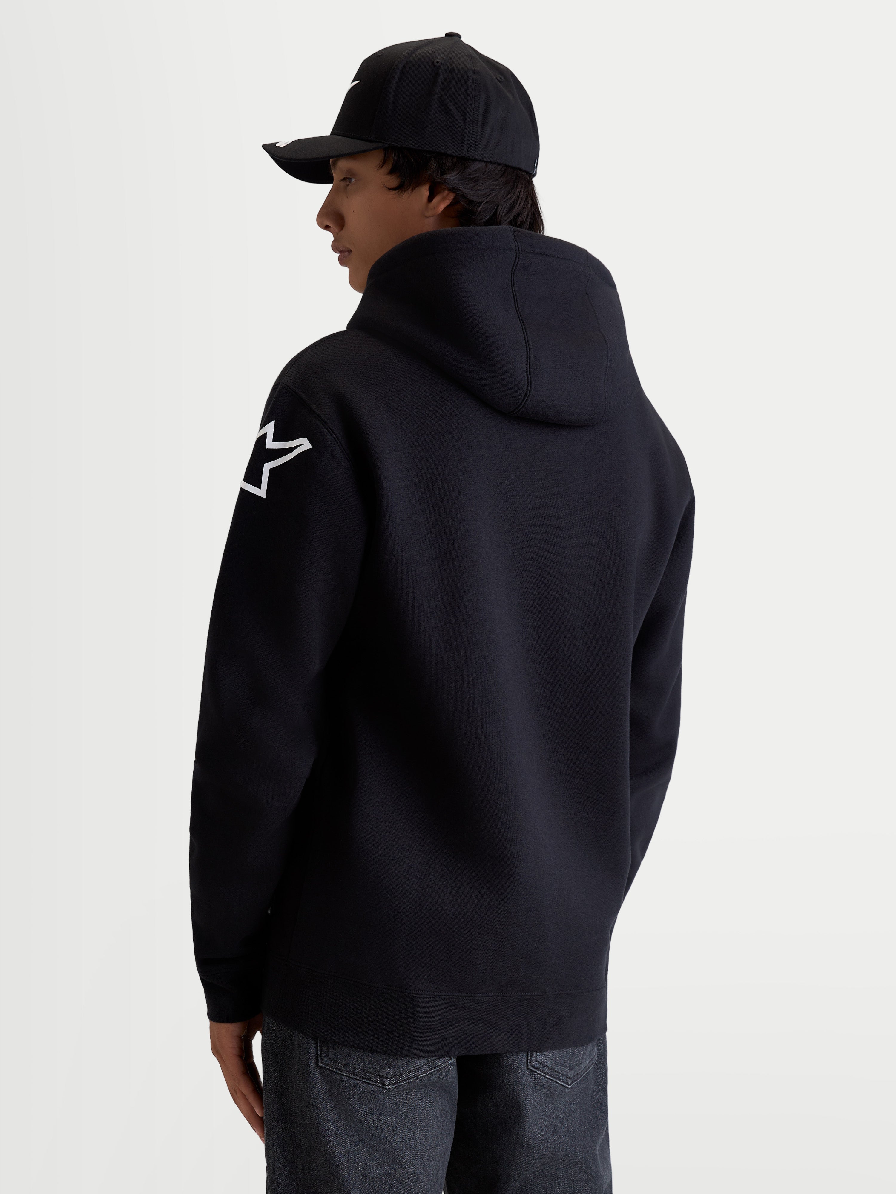 Alpinestars Velocifier Hoodie, Herren-Kapuzenpullover, Motorsport-Sportswear, Schwarz und Weiß, Baumwoll-Polyester-Mischgewebe, mit weißem Astars-Schulterlogo und Kapuze, Rückansicht am Model.