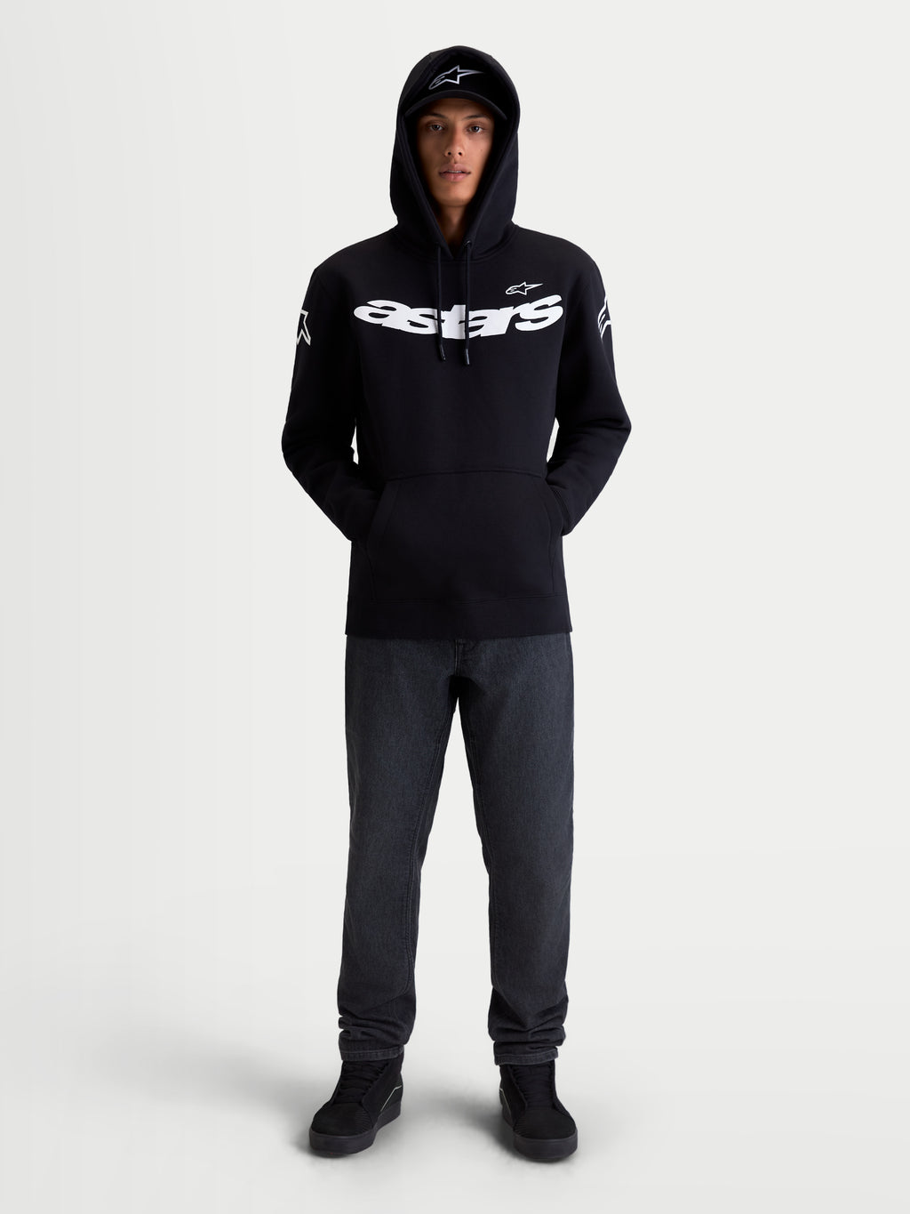 Alpinestars Velocifier Hoodie, Motorrad-Sportswear-Kapuzenpullover, Unisex, Schwarz und Weiß, Mischung aus Baumwolle und recyceltem Polyester, mit markantem Astars-Branding auf der Brust und Schulterlogos, Frontansicht am Modell für die Freizeit.