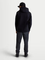 Alpinestars Velocifier Hoodie, Herren-Sportswear-Fleecepullover, Schwarz, Mischung aus Baumwolle und recyceltem Polyester, Rückansicht am Modell mit Kapuze und weißen Alpinestars-Logos an den Schultern.