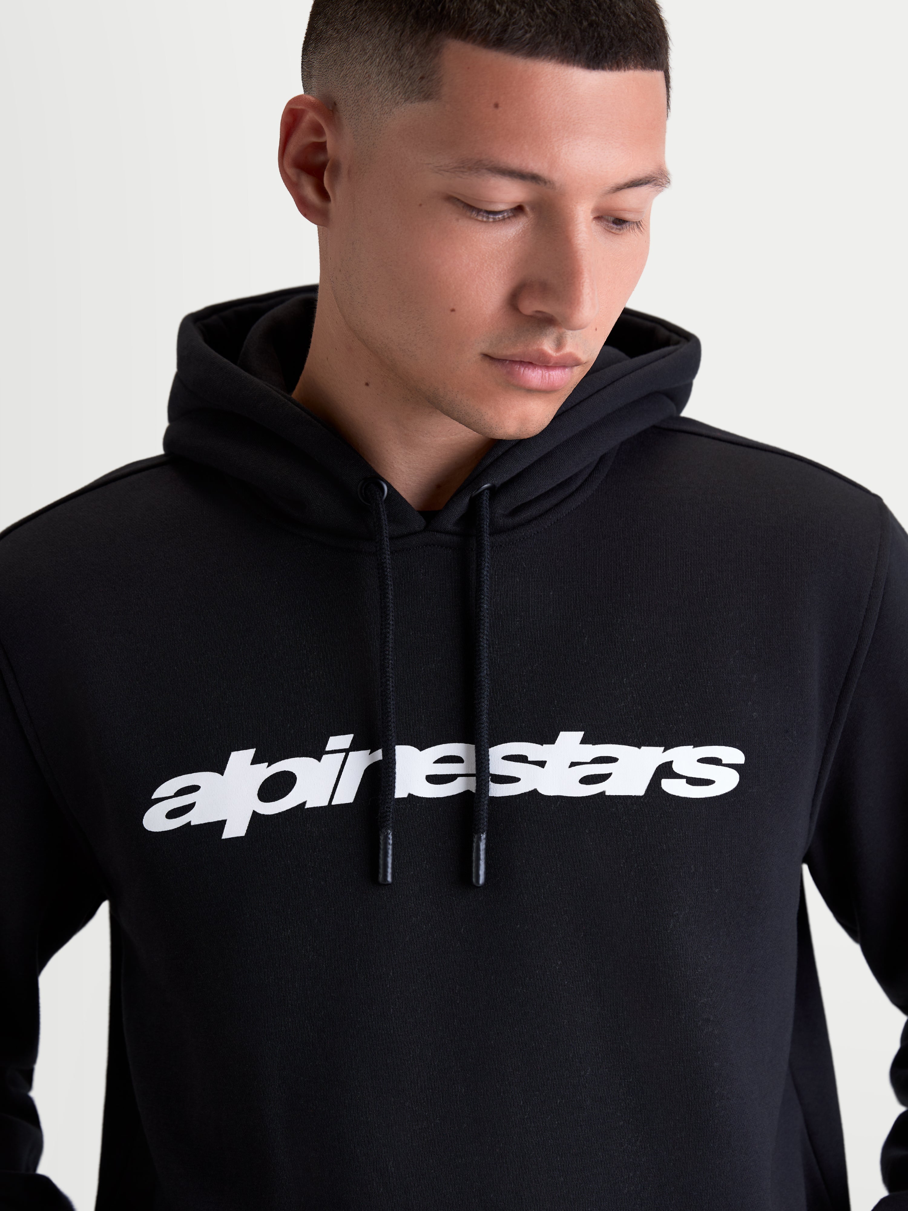 Alpinestars Race Wordmark Hoodie, Sportswear-Kapuzenpullover aus Fleece für Herren, Schwarz und Weiß, markanter Logo-Schriftzug auf der Brust, Kapuze mit Kordelzug und Kordelenden mit Tauchspitze, hochwertige Materialkonstruktion aus Baumwolle und recyceltem Polyester.