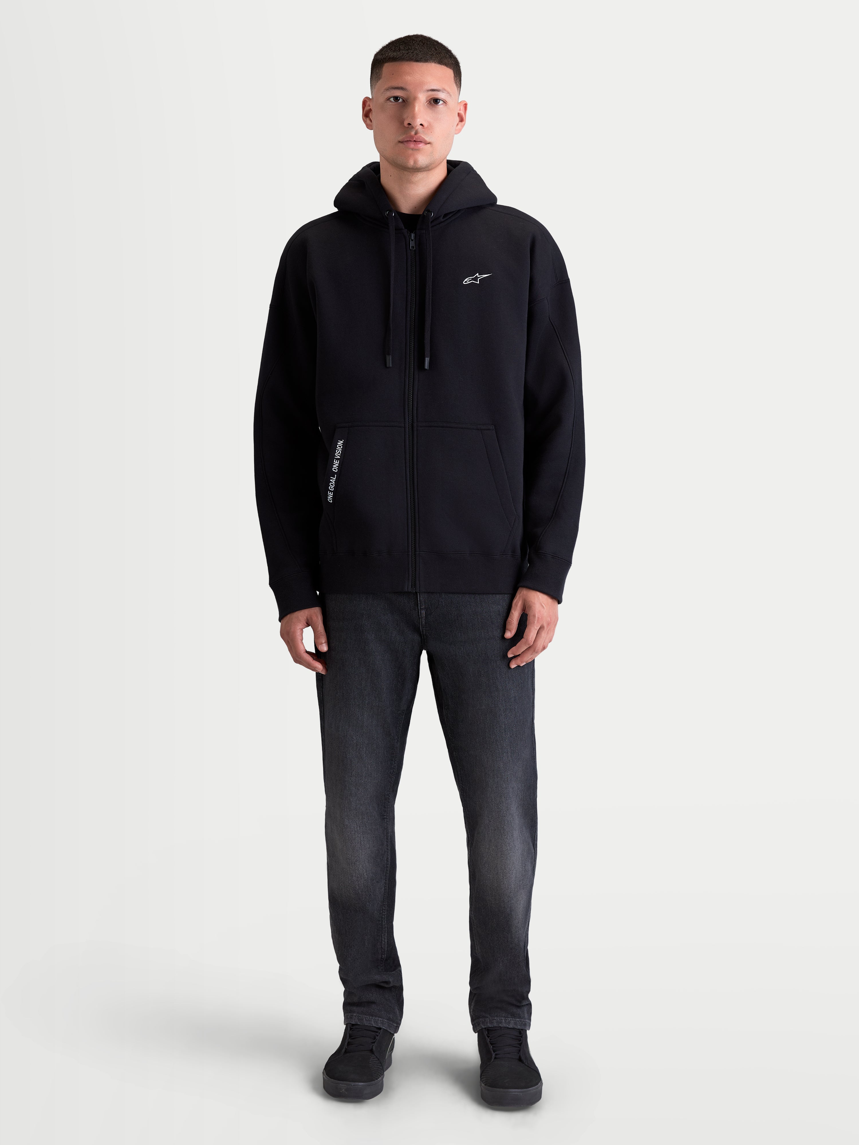 Alpinestars Pioneer Oversized Hoodie, Sportswear-Fleecehoodie, Schwarz, Oversized-Passform mit Vislon-Frontreißverschluss, Kängurutasche, gesticktes Alpinestars-Logo auf der Brust und 'One Goal. One Vision.' Detail.