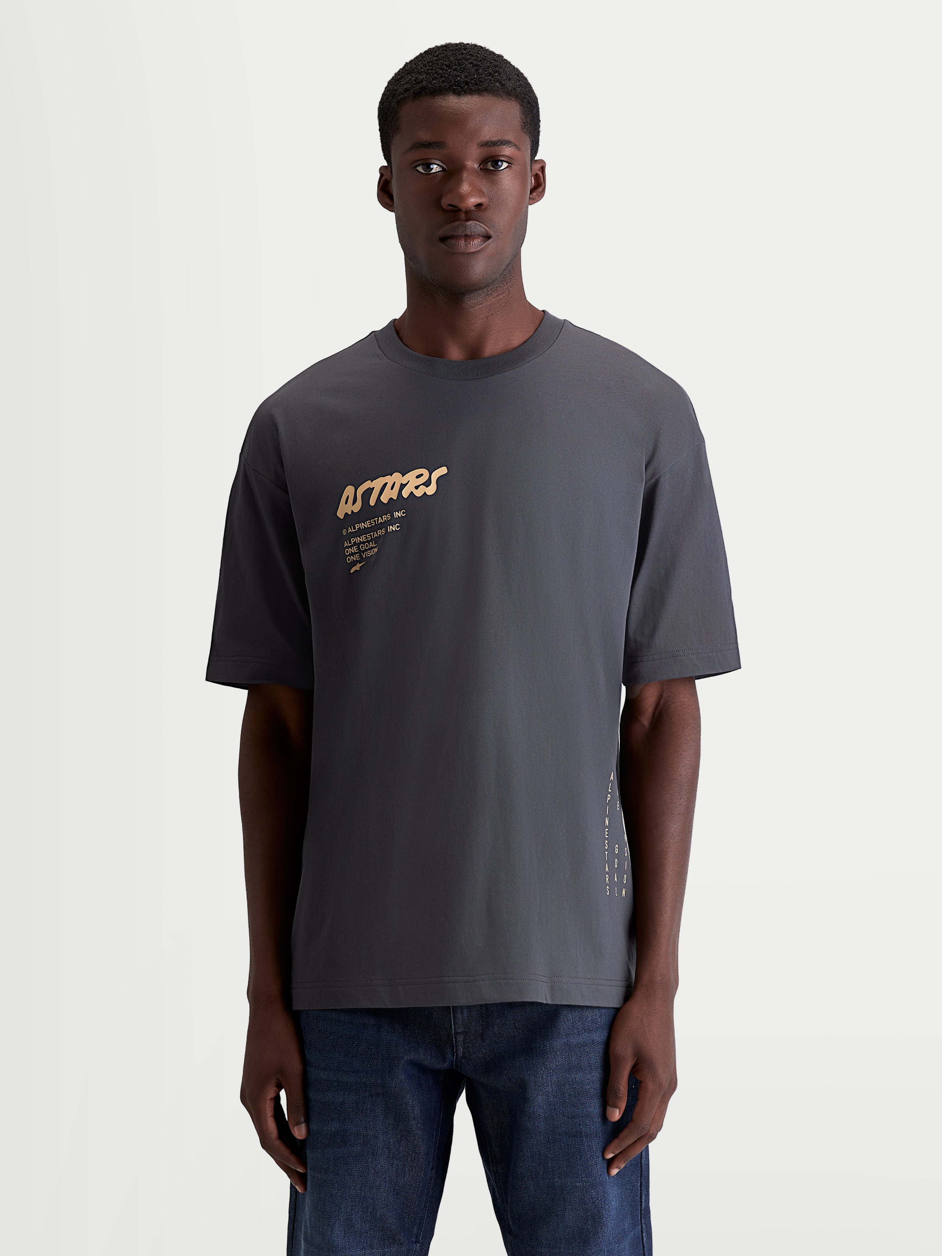 Alpinestars Chalk Oversized CSF T-Shirt, Kurzarm-Sportswear-T-Shirt, Grau mit hellbraunem Astars-Brustlogo und seitlichem Branding, entspannte Oversized-Passform, Baumwoll-Polyester-Mischung, am Modell gezeigt.