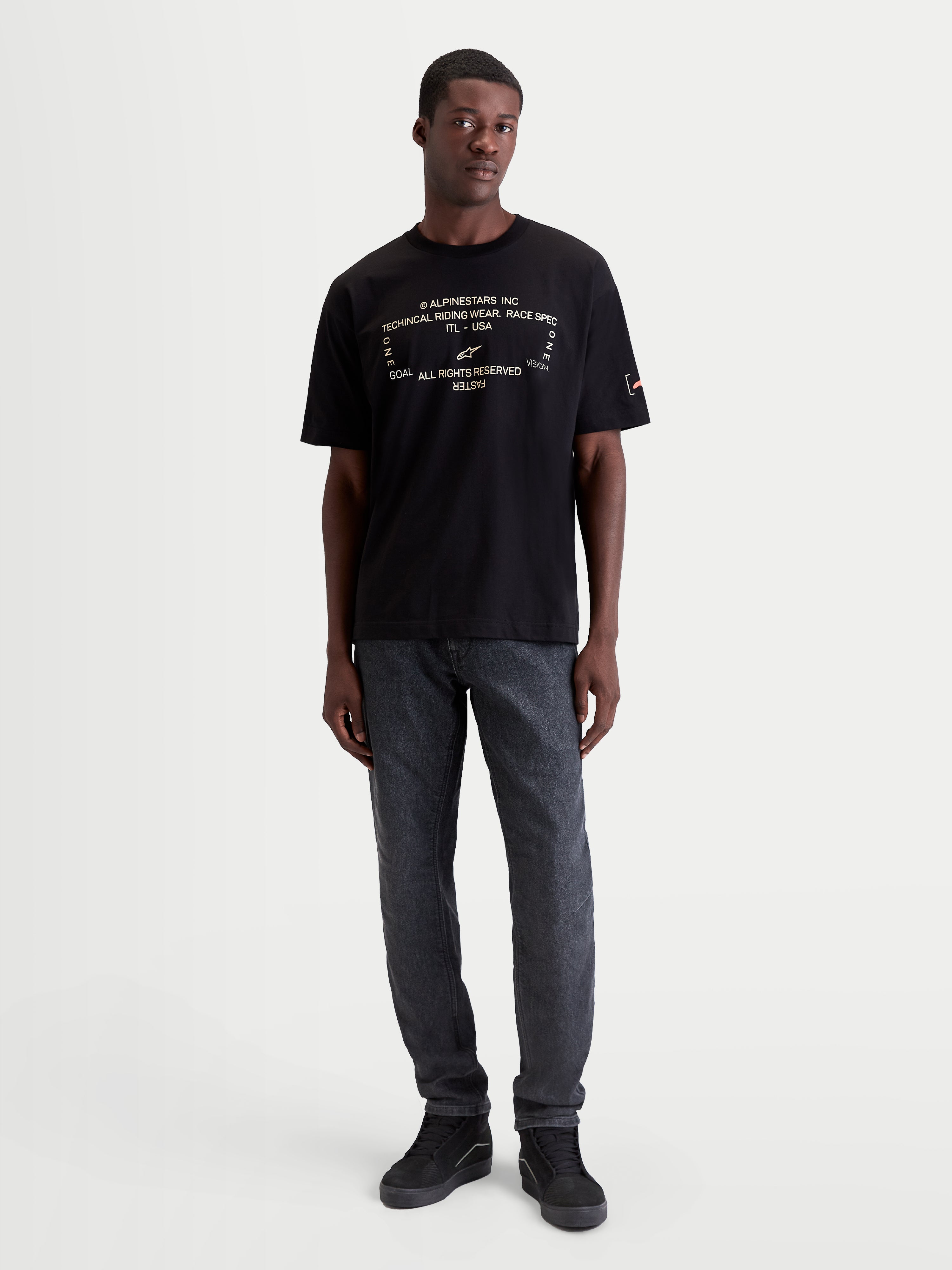 Alpinestars Infinity Oversized CSF T-Shirt, Herren-Kurzarm-Sportswear-T-Shirt in Schwarz mit technischer weißer Frontgrafik, lockere Passform, Baumwoll-Polyester-Mischung für Off-Bike-Komfort und Motorsport-Lifestyle, an einem Model gezeigt.