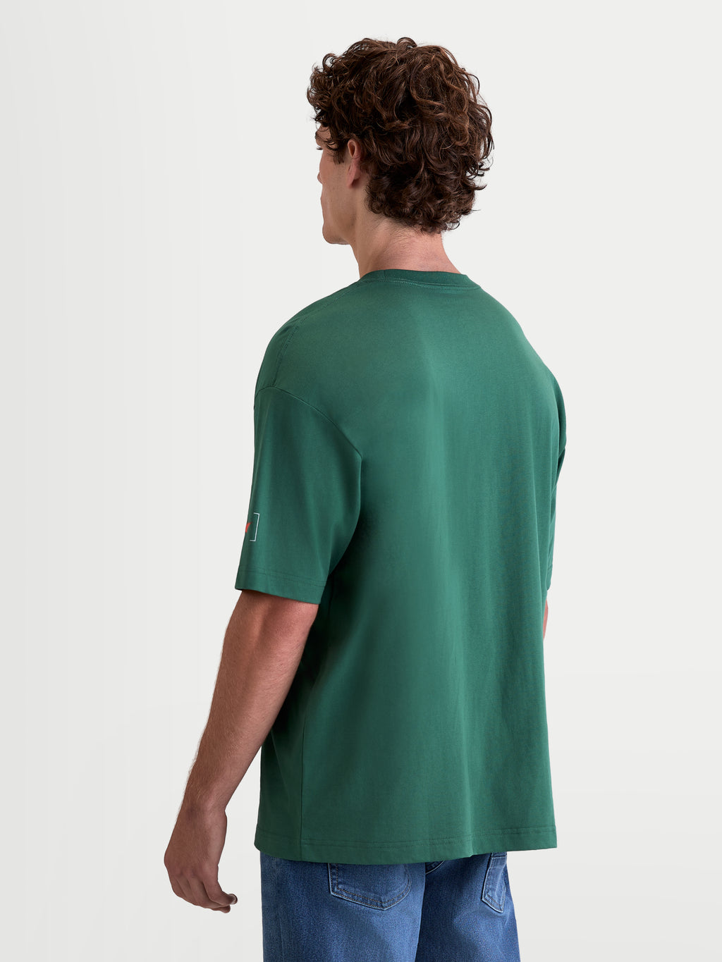 Alpinestars Infinity Oversized CSF T-Shirt, Herren-Kurzarm-Sport-T-Shirt, Grün, Oversized-Passform, Rückansicht am Modell mit Astars-Logo am Ärmel, Baumwoll-Polyester-Mischung.