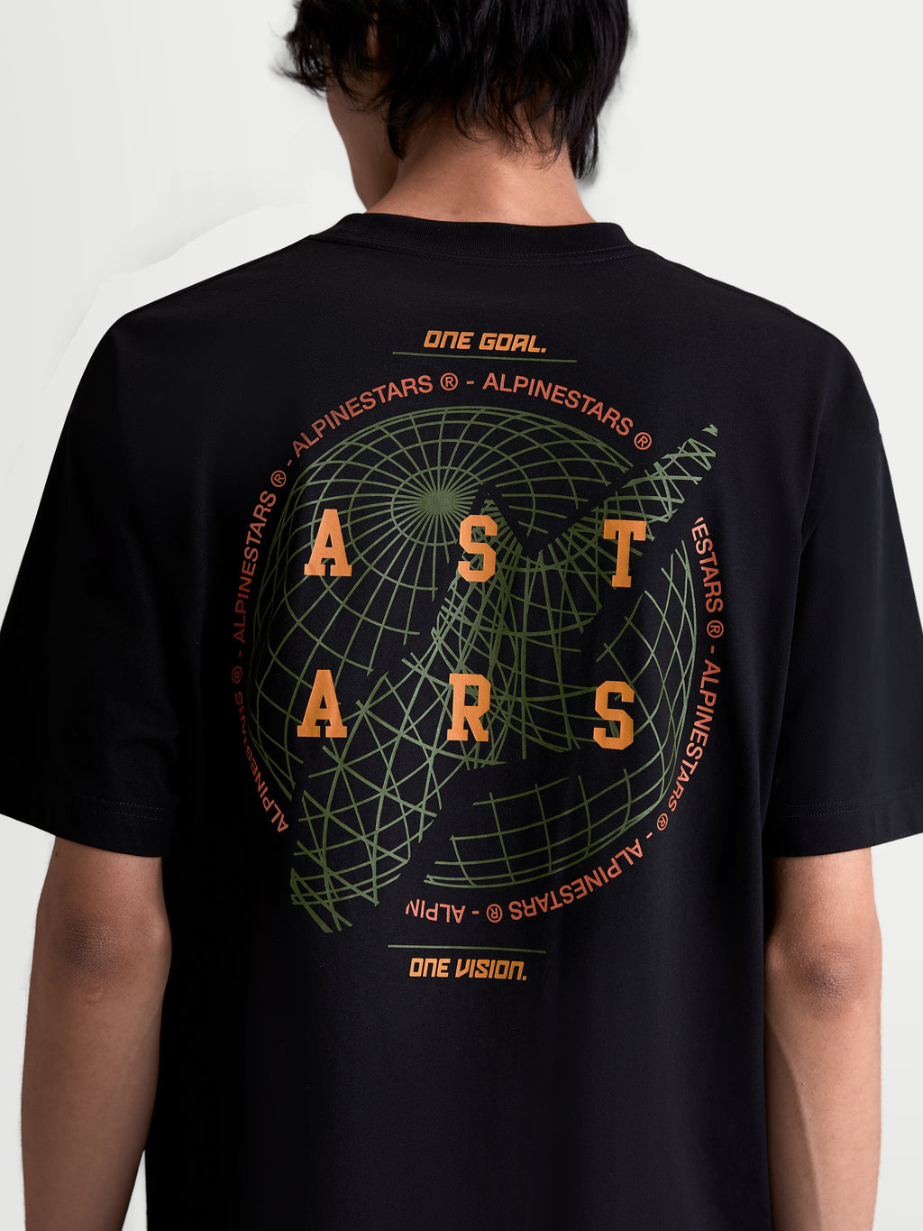 Alpinestars Latitude Oversized CSF T-Shirt, Kurzarm-Sportswear-Oberteil, Schwarz mit orangefarbenem ASTARS-Branding und grüner Globus-Grafik auf dem Rücken, Baumwoll-Polyester-Mischung, Rückansicht am Model.