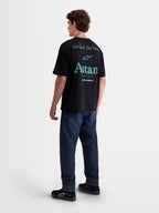 Alpinestars Post Oversized CSF T-Shirt, Herren-Sportswear-T-Shirt, Schwarz mit blaugrüner Rückengrafik, Rückansicht am Modell, zeigt „One Goal One Vision“ und „Astars Worldwide“ Schriftzug, weiche Baumwollmischung.